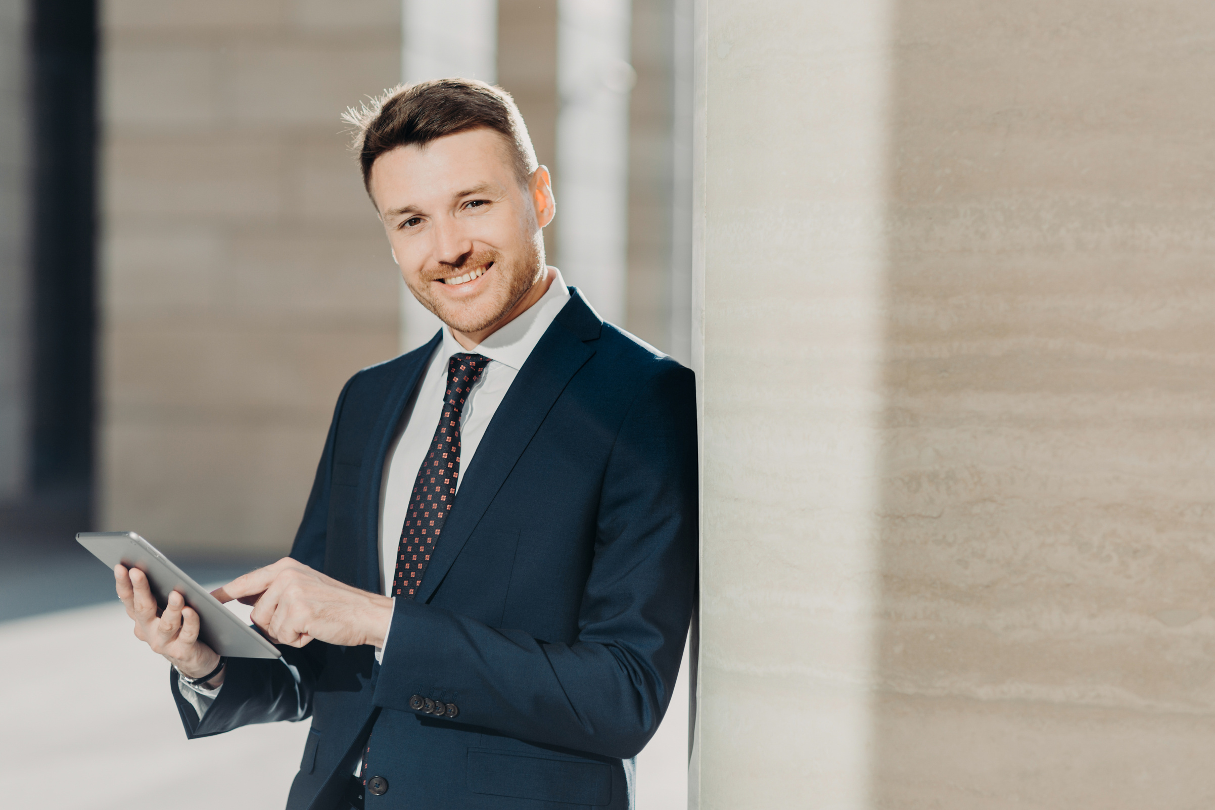 Experienced male economist in formal clothes works on digita